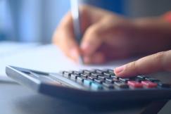 An illustrative photo of a finger pressing buttons on a calculator