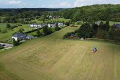 An illustrative photo of a field with a tractor and houses
