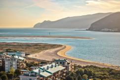 An illustrative photo of a beach in Portugal with mountains in the background