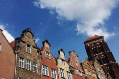 An illustrative photo of brown concrete buildings in Gdansk under blue sky during daytime