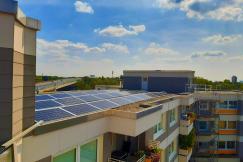 An illustrative photo of a rooftop view of a modern building equipped with solar panels