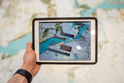 An illustrative photo of a person holding a white iPad with a black case
