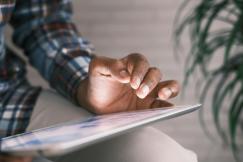 An illustrative photo of a person using a tablet.