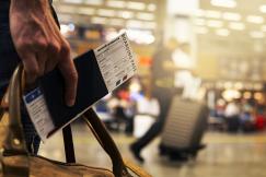 An illustrative photo of a traveler holding a boarding pass at an airport