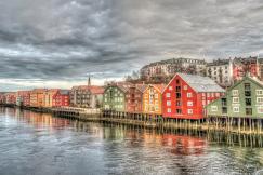 An illustrative photo of a row of multicoloured houses near a body of water