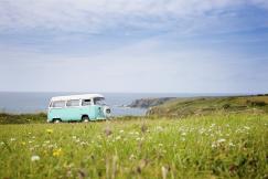 An illustrative photo of a vintage van parked on a grassy field.