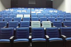 An illustrative photo of rows of blue and white chairs in a big room