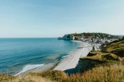 An illustrative photo of a view of a beach from a hill overlooking the ocean.