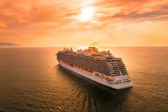 An illustrative photo of a white cruise ship on sea during sunset