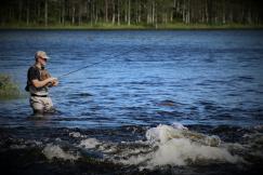 An illustrative photo of a person fishing on river during daytime