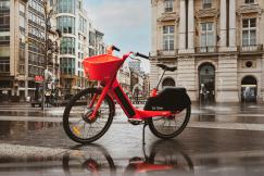 An illustrative photo of a red and black bicycle on road in the city