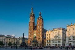 An illustrative photo of a brown church on the square with many people in Poland