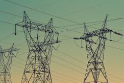 An illustrative photo of black transmission towers under green sky