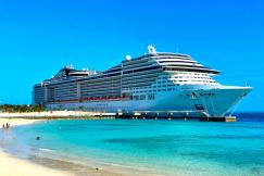 An illustrative photo of a white cruise ship in a sea near the beach