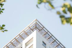 An illustrative photo of a tall building with a metal roof and a sky background