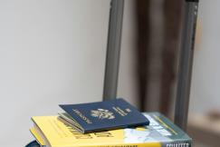 An illustrative photo of a suitcase with a book and a passport on top