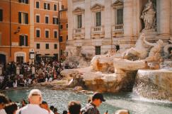 An illustrative photo of a crowd of people standing around a fountain.