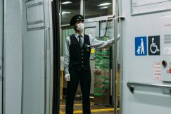 An illustrative photo of a man in a mask standing on the train station