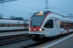 An illustrative photo of a red and white train arriving to the train platform