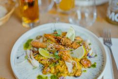 An illustrative photo of a plate of food on a table with wine glasses