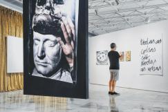 An illustrative photo of a man taking pictures of a painting in the gallery