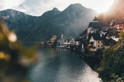 An illustrative photo of a town beside body of water and mountains.