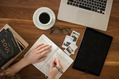 An illustrative photo of a person writing on notebook.