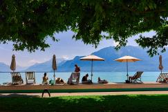 An illustrative photo of people sitting under umbrellas.