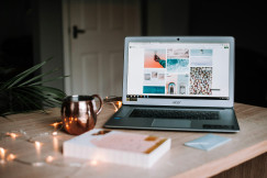 An illustrative photo of a laptop on table near a cup.