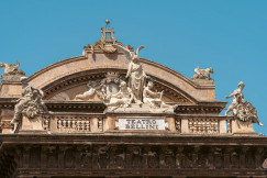 An illustrative photo of a large building with statues on top of it