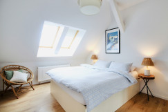 An illustrative photo of a light bedroom with a white bed in it