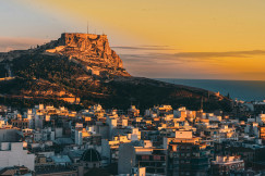 An illustrative photo of a view of a city during sunset with a mountain in the background