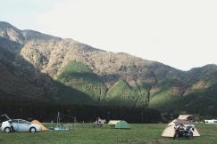 An illustrative photo of dome tents near mountains.