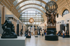 An illustrative photo of a group of people walking around a museum.