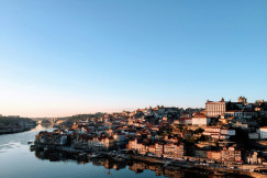 An illustrative photo of city buildings near river under blue sky