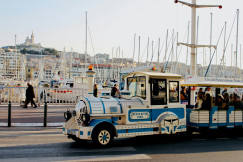 An illustrative photo of white and blue tourist train on the road