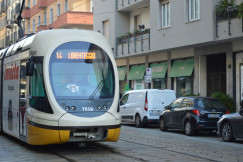 An illustrative photo of a yellow and white bus on the streets of Milan