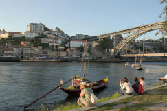 An illustrative photo of a group of people sitting on the side of a river.