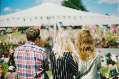 An illustrative photo of three people standing on a festival
