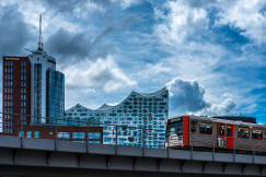 An illustrative photo of a train running on rail near buildings during daytime