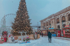 An illustrative photo of people walking near christmas tree.