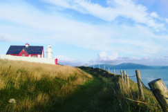 An illustrative photo of a lighthouse near green grass field.