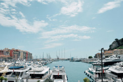 An illustrative photo of yachts on the coast near buildings