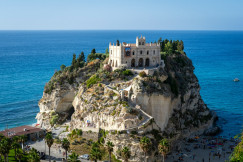 An illustrative photo of a castle on a hill next to the ocean