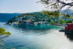 An illustrative photo of houses on a hill near a body of water
