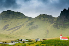 An illustrative photo of houses near hills.