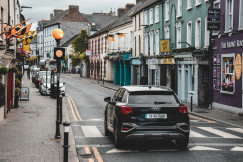 An illustrative photo of a car driving down a street.