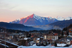 An illustrative photo of a town with snow covered mountains