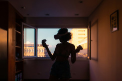 An illustrative photo of a person standing near window.