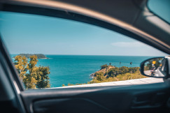 An illustrative photo of coastal view through vehicle window.